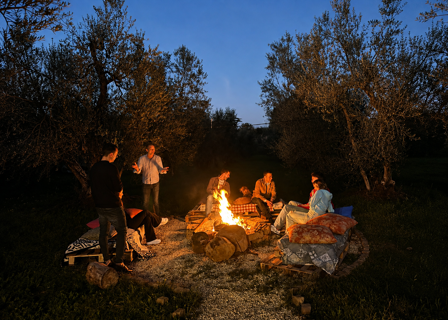Momento serale attorno al fuoco all'aperto tra gli ulivi